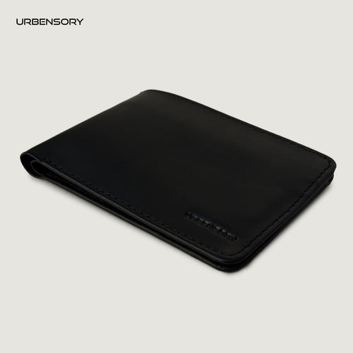 The Zero black leather bifold wallet by URBENSORY, shown closed at a three-quarter angle with stitched edges and an embossed logo.